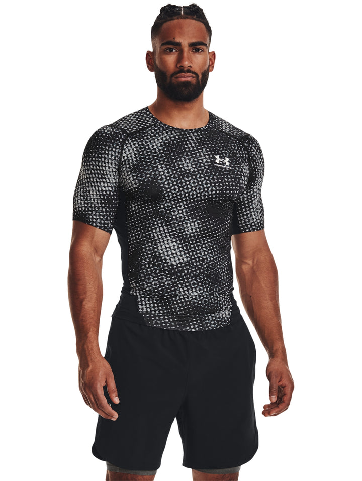 Hombre vistiendo camiseta de compresión Under Armour con estampado en color negro y gris.