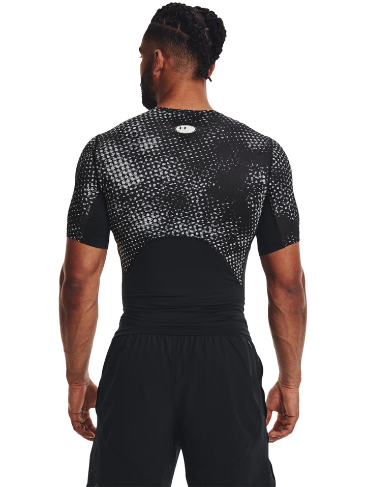 Hombre vistiendo camiseta de compresión Under Armour con estampado en color negro y gris.