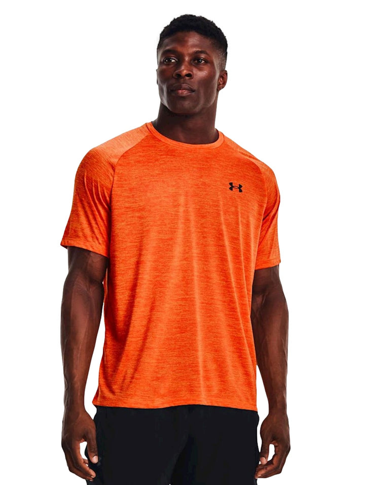 Hombre vistiendo camiseta deportiva de manga corta color naranja marca Under Armour.