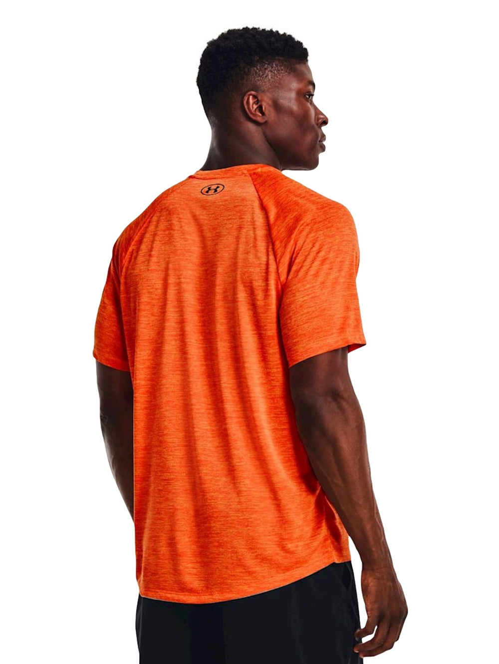 Hombre vistiendo camiseta deportiva de manga corta color naranja marca Under Armour.
