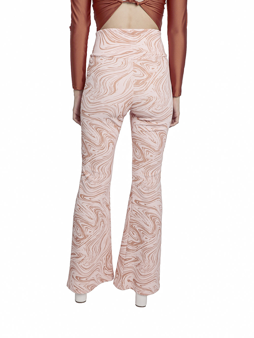 Pantalones acampanados color rosa con diseño marmoleado en tonos terracota.