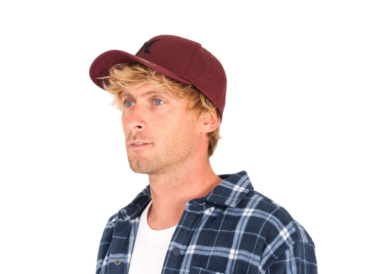 Gorra Hurley color mahogany con logo frontal negro y etiqueta Flexfit en la visera.