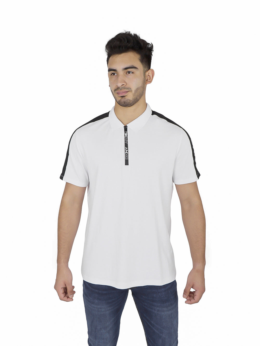 Hombre vistiendo playera polo blanca DKNY con detalles negros en hombros y cuello.