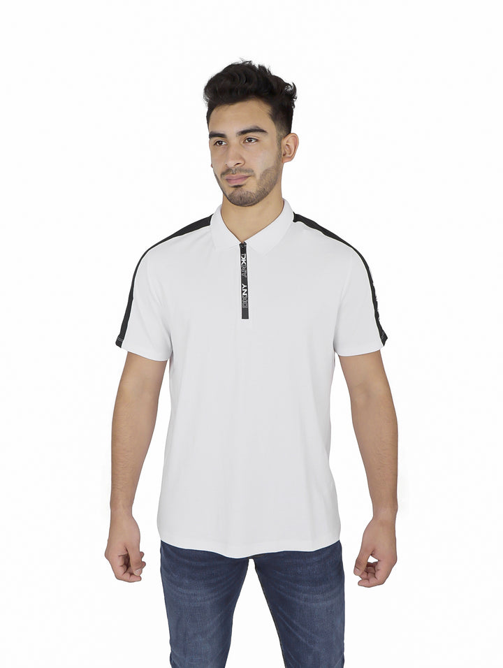 Hombre vistiendo playera polo blanca DKNY con detalles negros en hombros y cuello.