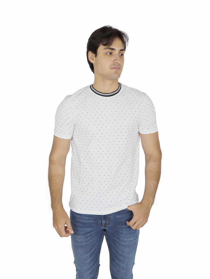 Hombre vistiendo camiseta blanca de manga corta con estampado de puntos y cuello contrastado.