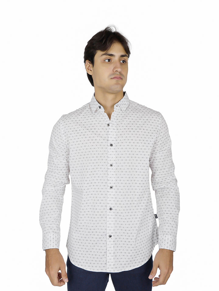Hombre vistiendo una camisa blanca de manga larga con un estampado repetitivo pequeño y botones.