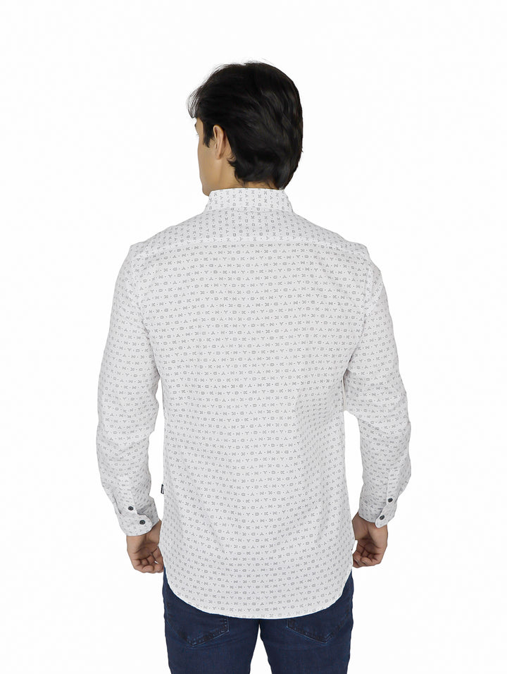 Hombre vistiendo una camisa blanca de manga larga con un estampado repetitivo pequeño y botones.