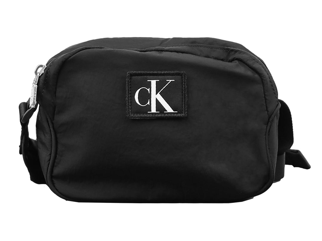 Bolsa de hombro pequeña tipo camera bag de Calvin Klein en color negro con logotipo frontal blanco.