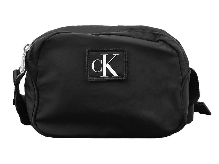 Bolsa de hombro pequeña tipo camera bag de Calvin Klein en color negro con logotipo frontal blanco.