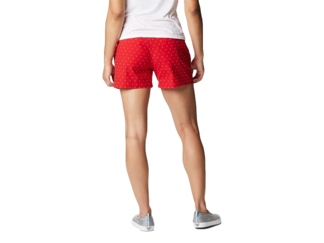 Mujer vistiendo shorts cortos color rojo con patrón de puntos blancos de la marca Columbia.