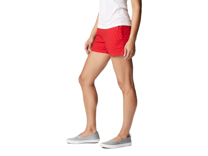 Mujer vistiendo shorts cortos color rojo con patrón de puntos blancos de la marca Columbia.