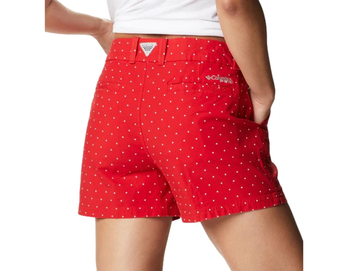 Mujer vistiendo shorts cortos color rojo con patrón de puntos blancos de la marca Columbia.