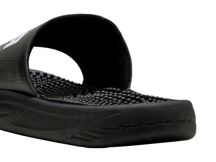 Sandalia deslizable PUMA de color negro con logotipo blanco y suela texturizada para masaje.
