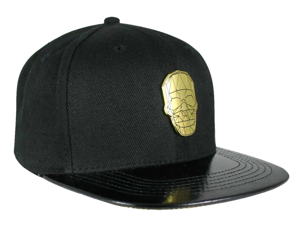 Gorra snapback color negro con visera plana y un emblema dorado en forma de calavera geométrica al frente.