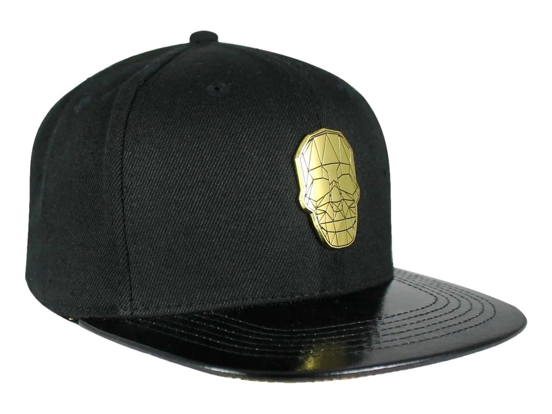 Gorra snapback color negro con visera plana y un emblema dorado en forma de calavera geométrica al frente.