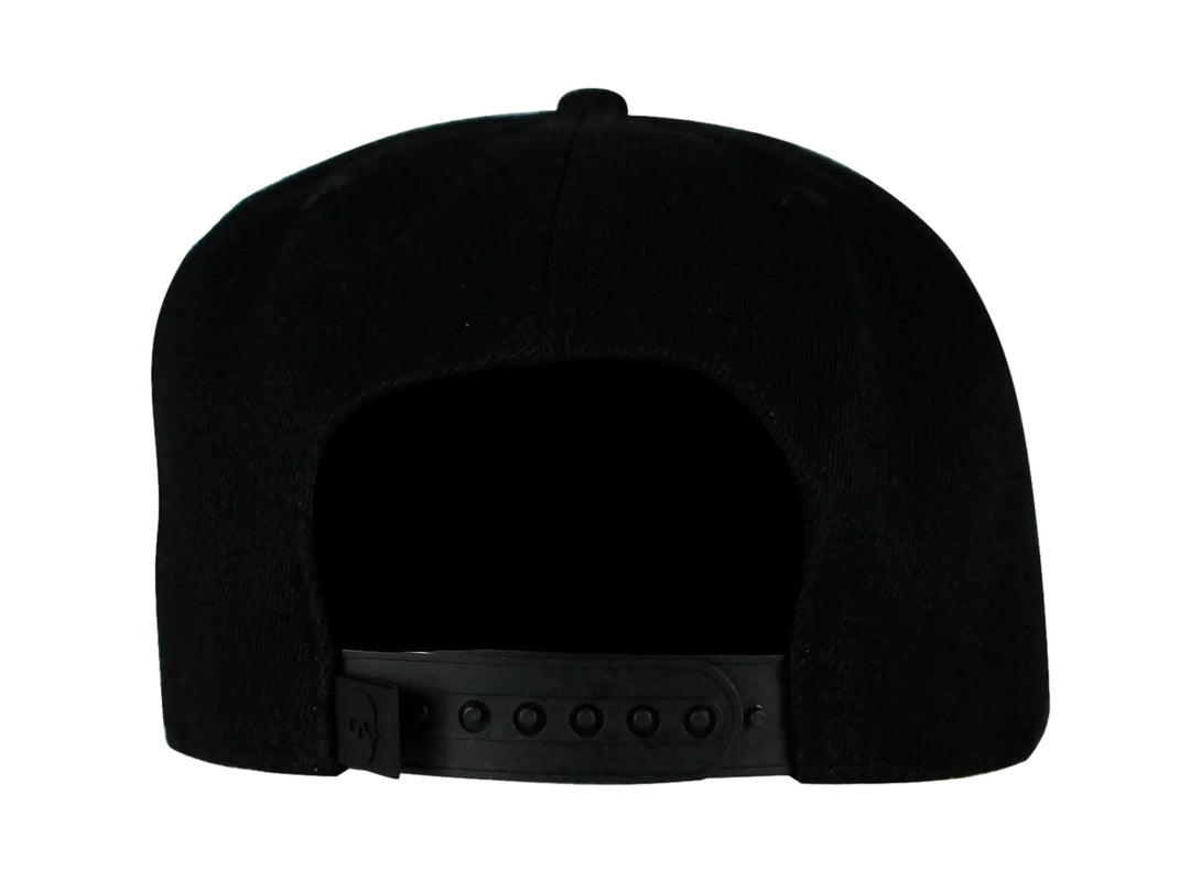 Gorra snapback color negro con visera plana y un emblema dorado en forma de calavera geométrica al frente.