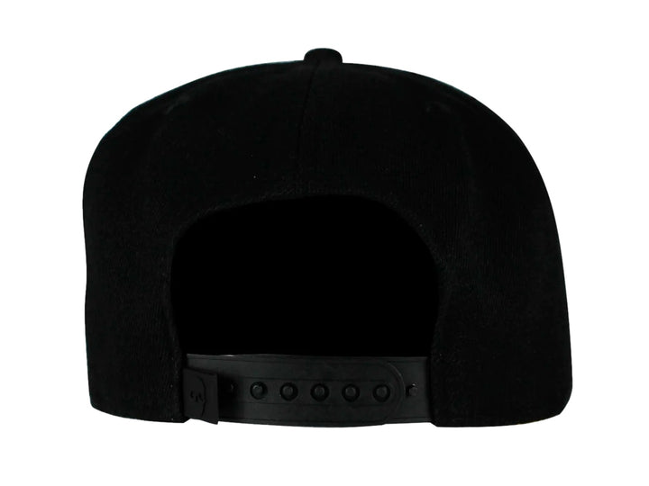 Gorra snapback color negro con visera plana y un emblema dorado en forma de calavera geométrica al frente.