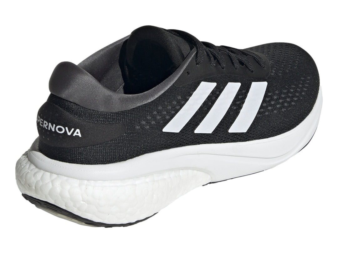 Tenis deportivos Adidas Supernova 2.0 en color negro con franjas y suela blanca.