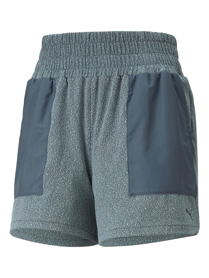 Mujer vistiendo shorts deportivos PUMA color gris oscuro con diseño de bloques de color.