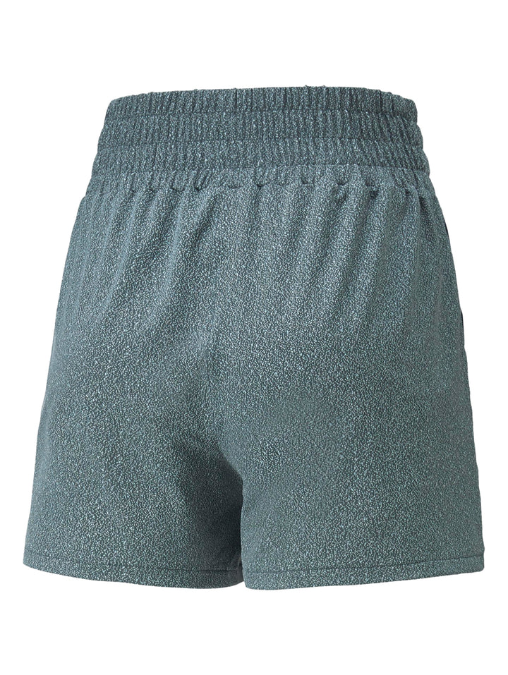 Mujer vistiendo shorts deportivos PUMA color gris oscuro con diseño de bloques de color.