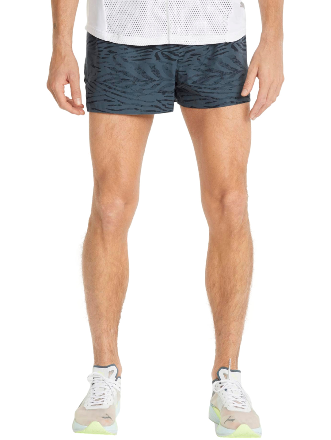 Hombre vistiendo shorts deportivos PUMA color gris oscuro con corte split para running.