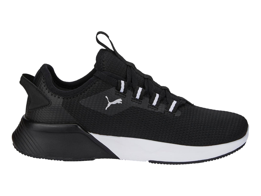Tenis deportivos PUMA para niños en color negro con suela blanca y logotipo lateral blanco.