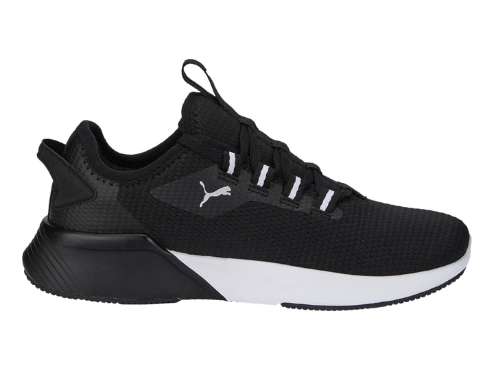 Tenis deportivos PUMA para niños en color negro con suela blanca y logotipo lateral blanco.