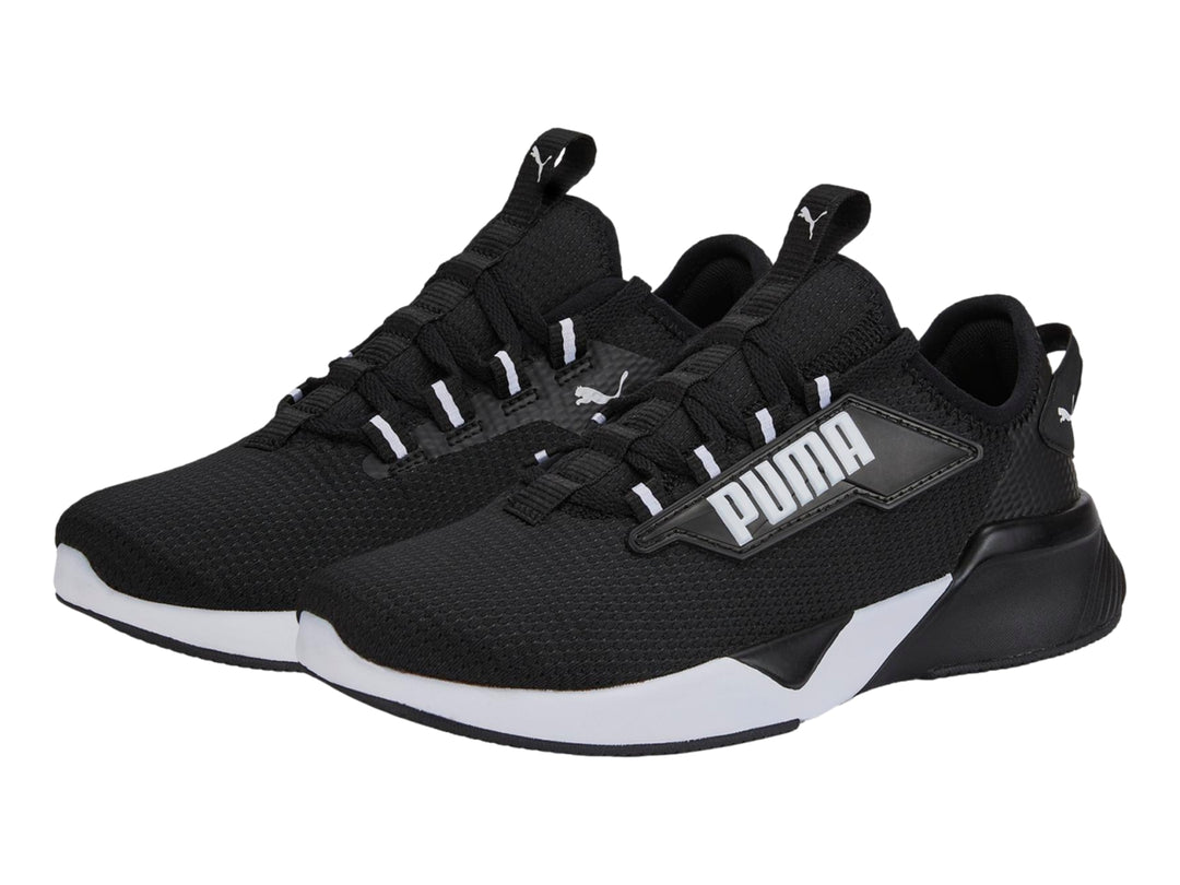 Tenis deportivos PUMA para niños en color negro con suela blanca y logotipo lateral blanco.