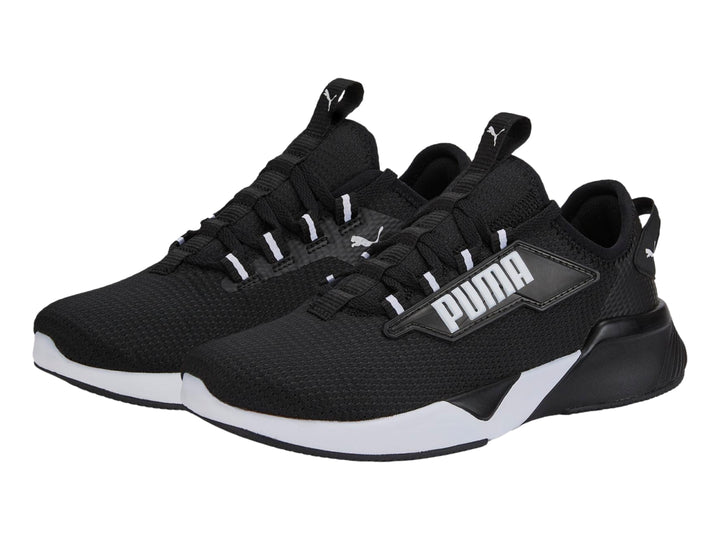 Tenis deportivos PUMA para niños en color negro con suela blanca y logotipo lateral blanco.