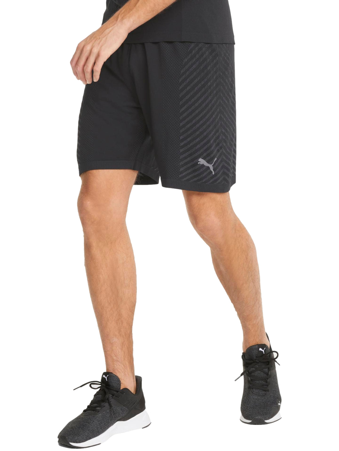 Hombre vistiendo pantalones cortos deportivos color negro marca PUMA con textura diagonal.