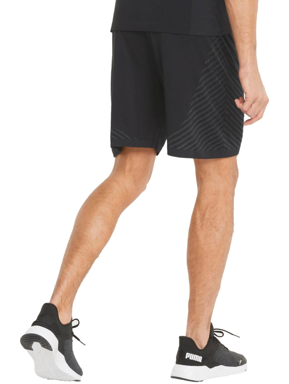 Hombre vistiendo pantalones cortos deportivos color negro marca PUMA con textura diagonal.