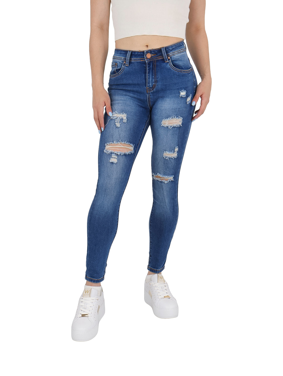 Mujer vistiendo pantalones jeans ajustados color azul con efectos de destrucción y roturas.