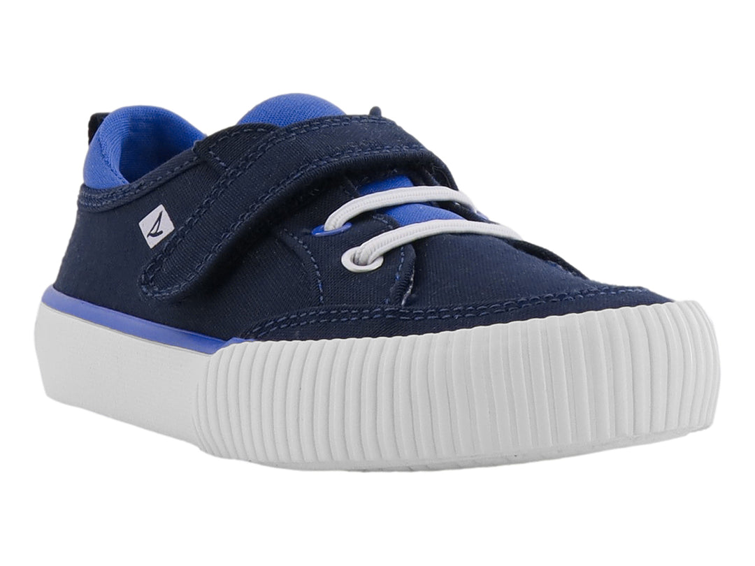 Zapato infantil Sperry color azul marino con suela blanca, cierre de velcro y agujetas decorativas.