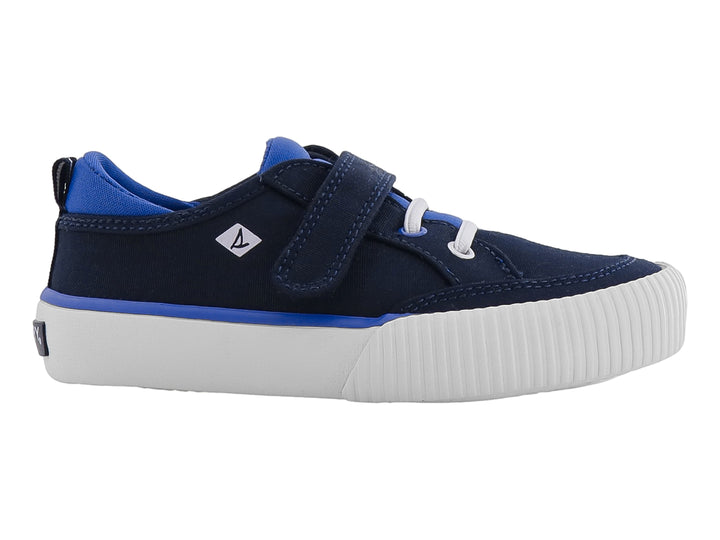 Zapato infantil Sperry color azul marino con suela blanca, cierre de velcro y agujetas decorativas.