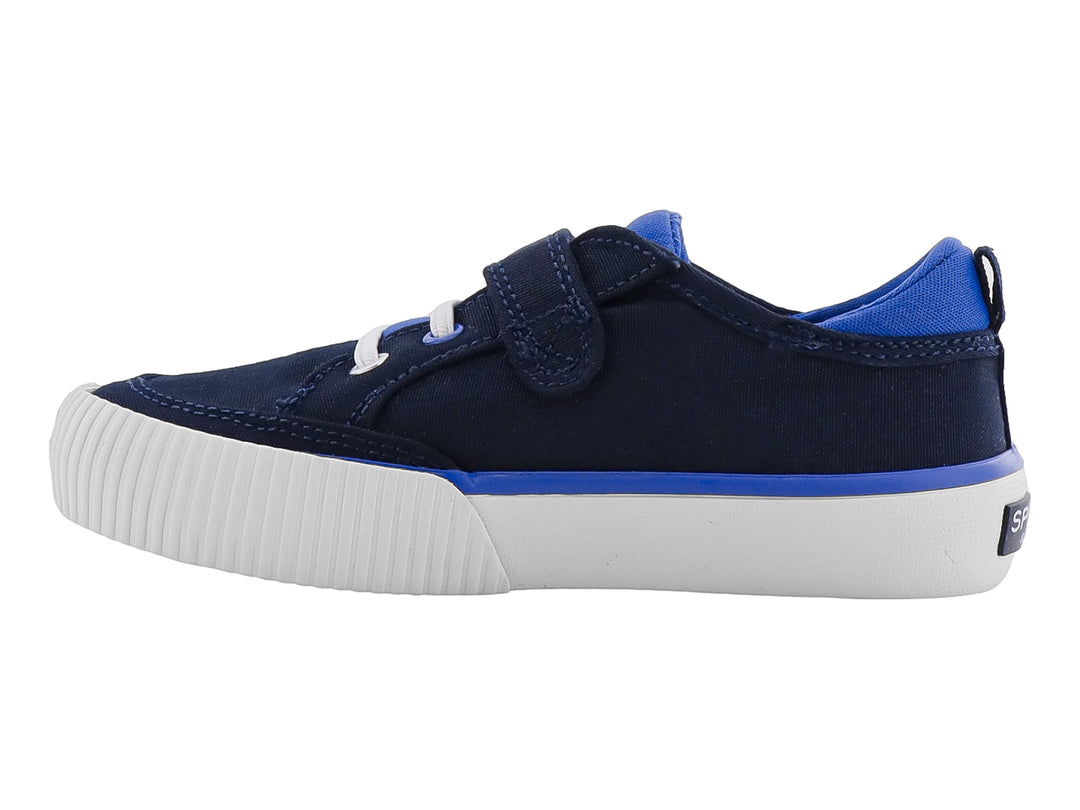 Zapato infantil Sperry color azul marino con suela blanca, cierre de velcro y agujetas decorativas.