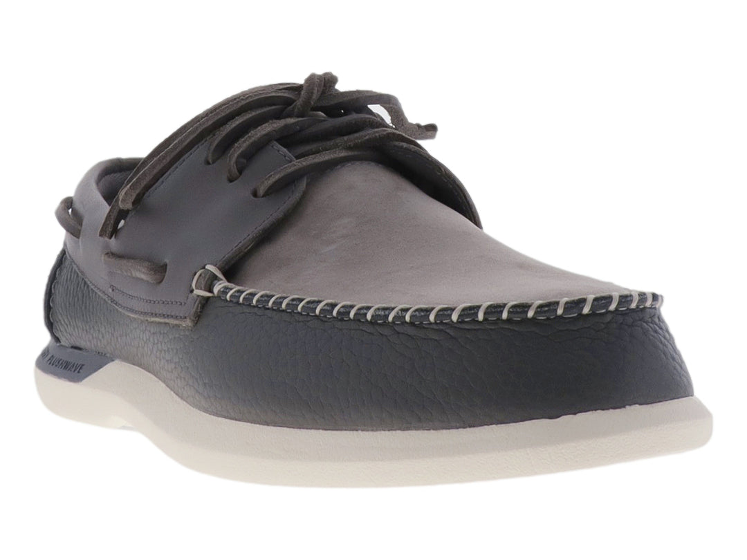 Zapato náutico Sperry de color gris con suela blanca y cordones.