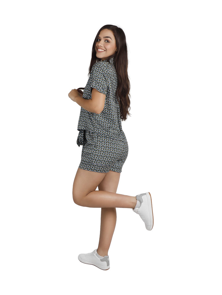 Mujer con conjunto de camisa y shorts de satín azul con estampado blanco.