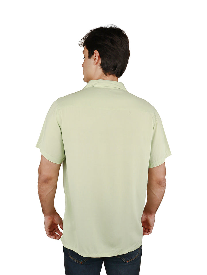 Hombre vistiendo una camisa casual de manga corta en color verde claro con un bolsillo frontal.