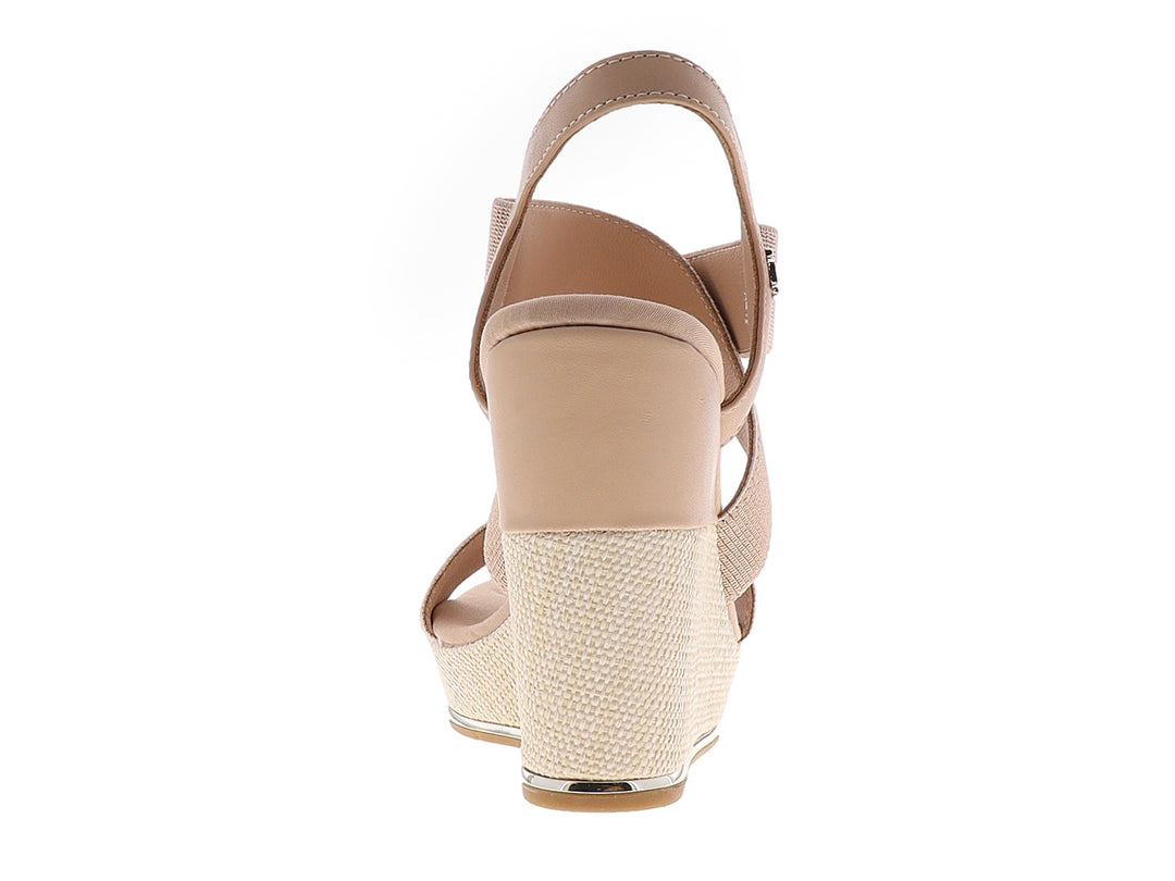 Sandalia de plataforma color beige con tiras elásticas cruzadas y tacón de cuña texturizado.