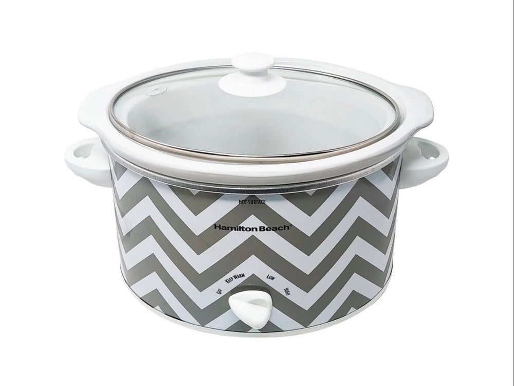 Olla de cocción lenta Hamilton Beach blanca con diseño de zig-zag gris y tapa de vidrio transparente.