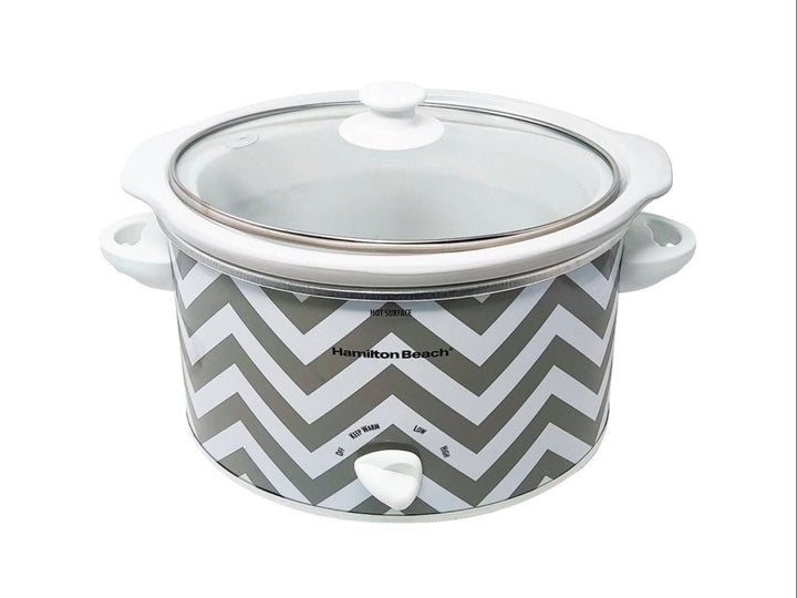 Olla de cocción lenta Hamilton Beach blanca con diseño de zig-zag gris y tapa de vidrio transparente.