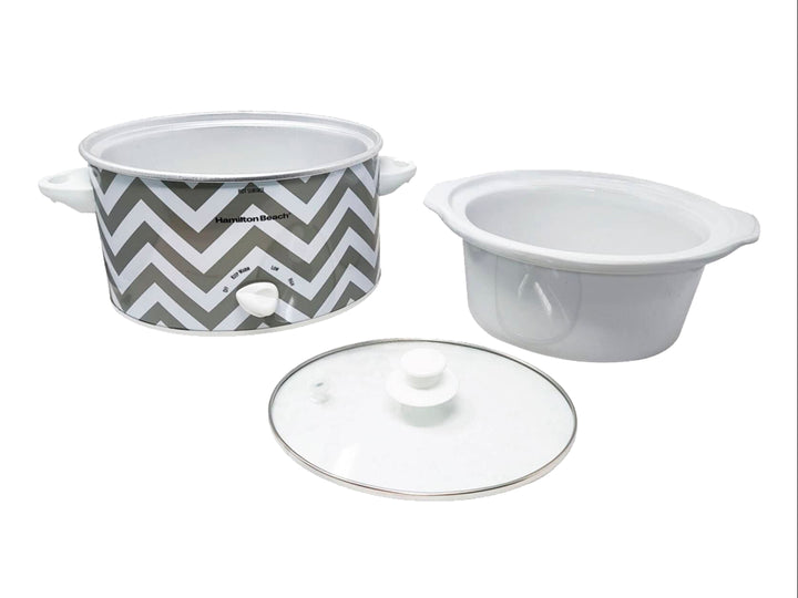 Olla de cocción lenta Hamilton Beach blanca con diseño de zig-zag gris y tapa de vidrio transparente.