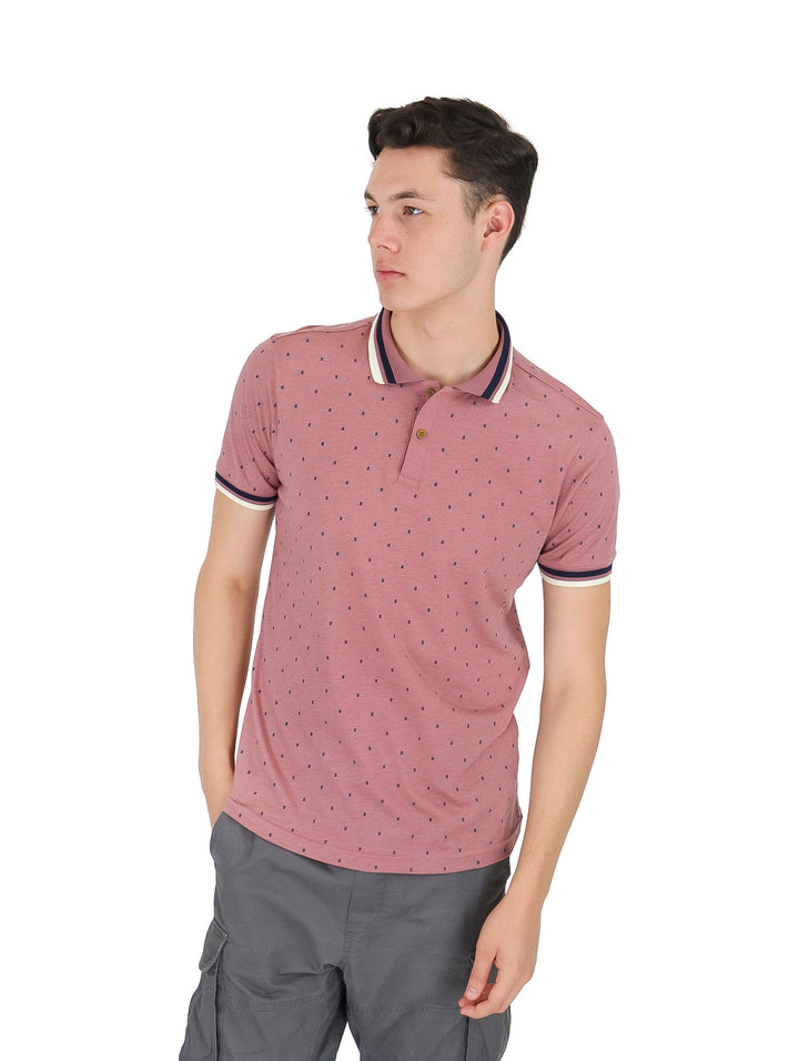Hombre vistiendo playera tipo polo color rosa con pequeños puntos y detalles en el cuello y mangas.