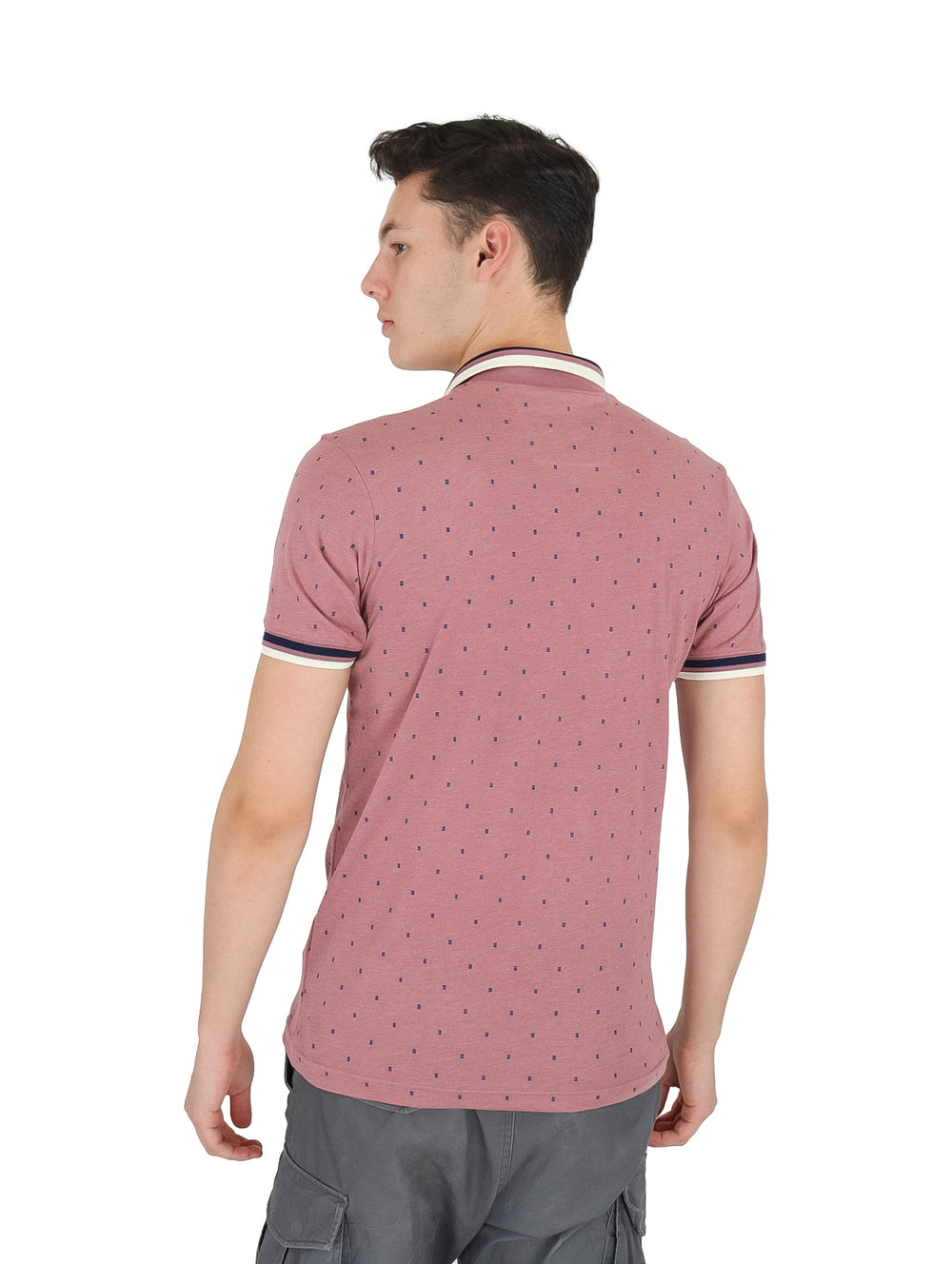 Hombre vistiendo playera tipo polo color rosa con pequeños puntos y detalles en el cuello y mangas.