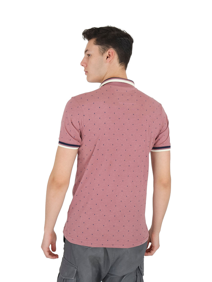 Hombre vistiendo playera tipo polo color rosa con pequeños puntos y detalles en el cuello y mangas.
