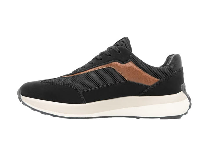 Tenis Flexi color negro con detalles en marrón y suela blanca gruesa.