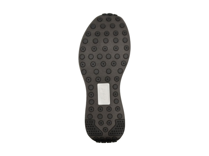 Tenis Flexi color negro con detalles en marrón y suela blanca gruesa.