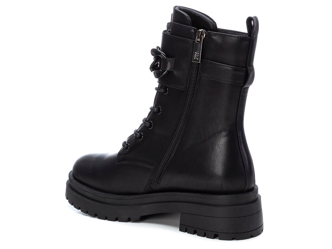 Bota negra de caña media con suela track, agujetas, hebilla lateral y detalles de estoperoles plateados.