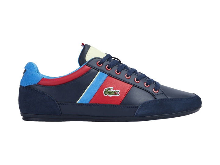 Tenis Lacoste azul marino con franjas laterales en rojo, azul y amarillo y logotipo del cocodrilo.