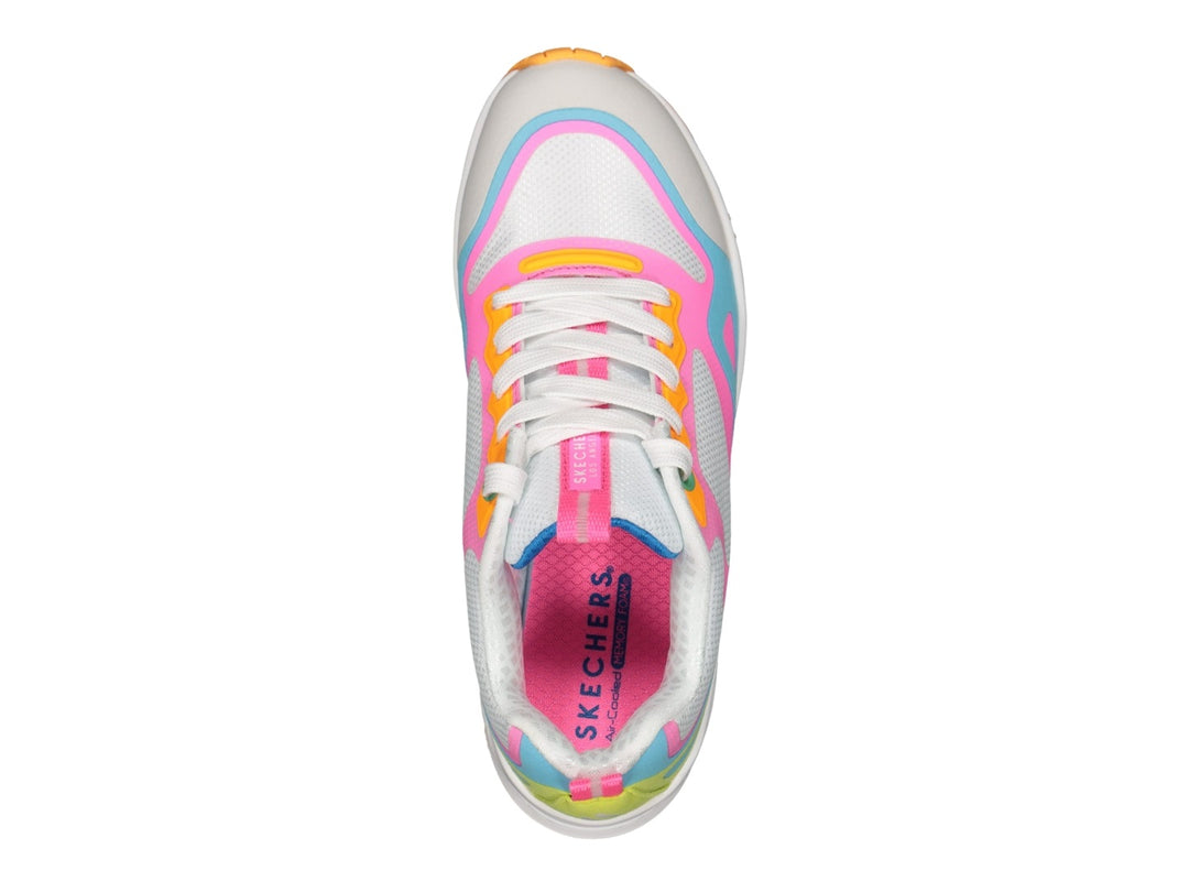 Tenis deportivos Skechers multicolores en blanco, rosa, azul y amarillo con suela blanca y amortiguador transparente.